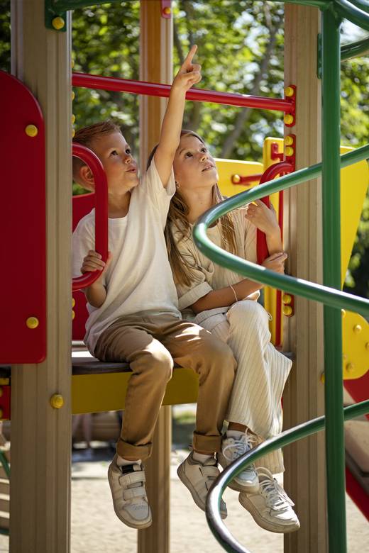 Spielplatzprüfung Kind sitzt in einem Spielplatzgerät
